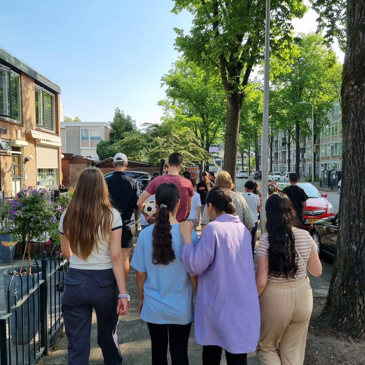 Kinderen lopen schouder aan schouder door een wijk